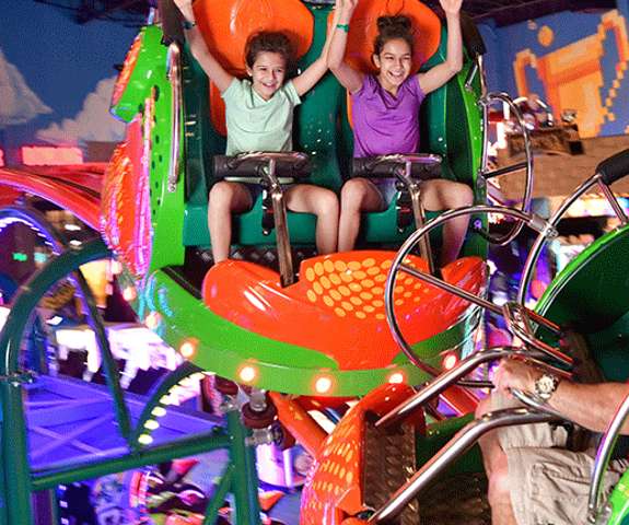 Family Riding the Scream'n Centipede Roller Coaster in Tom Foolerys Adventure Park