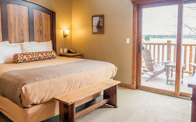 Cottage room with a king size bed and a glass sliding door showing the lake