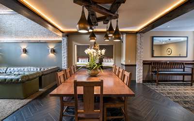 an overview of inside the Big Five Suite. Consists of a bedroom with dining area, kitchen, and a pool table.