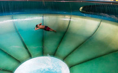 a young boy swirling around a water slide