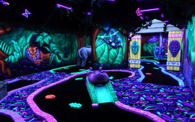 blacklight mini golf course with a glowing jungle and jungle animals