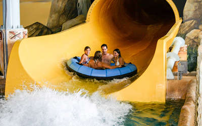 some friends sliding down the victoria falls slide in the indoor waterpark