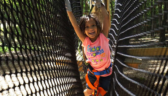 Little girl doing ropes course in Gorilla Grove Treetop Adventures