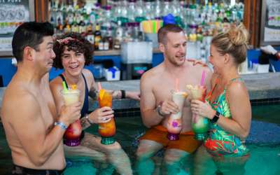 Two couples in the the indoor swim-up bar enjoying monster cocktails.