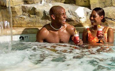 A couple enjoying beverages in the hot tub