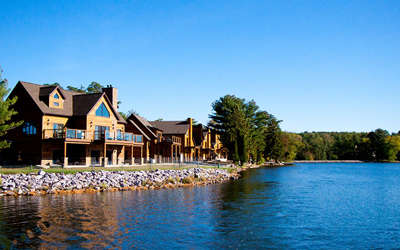 multiple log cabins next to the lake